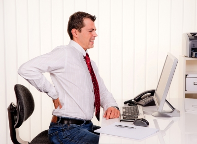 man sitting at desk with back pain